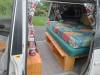 Side door open on the FQK81 campervan, bed on its timber frame with the bench alongside