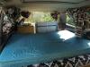 Inside the FQK81 campervan looking forward over the bed to the sink unit and the seat backs