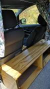 Timber bench built behind the front seats of the FYC899 Toyota Estima campervan