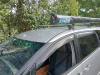 Rolled awning mounted on the JTQ214 campervan's roof rack, seen from the front corner
