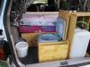 Tailgate open on the FPS382 campervan, with the sink unit, portable toilet and water container