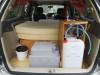 Tailgate open on the GRH325 campervan, showing the bed, portable toilet, sink unit and water container