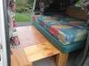 Inside the FQK81 campervan, bed cushion on its timber base with the plywood table folded out