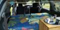 Inside the GBB26 campervan looking forward over the bed to the front seats, sink unit on the right