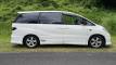 Side view of the white 2001 Toyota Estima campervan FJD528 parked on a country road