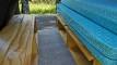 Bed platform in the FYC899 campervan, plywood benches either side of the carpeted floor space