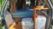Inside the FAC789 campervan with the portable toilet and the fresh water container stowed under the bench