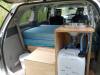 Tailgate open on the KHP570 campervan, showing the bed, sink unit and fresh water container