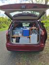 The JAK653 campervan packed for a road trip, kitchen unit, chilly bin and water container in the back