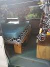 Inside the FQK81 campervan, bed made up on the timber base with patterned curtains at the windows