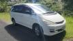 White 2005 Toyota Estima self-contained campervan for sale, front three-quarter view on a country road