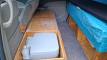 Portable toilet stowed in the bench seat of the EYC409 campervan, lid lifted