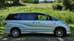 Side view of the silver 2002 Toyota Estima campervan FYC899 parked on grass