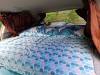 Bed made up with a duvet in the JAK653 campervan, looking out through the rear window