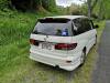 Rear three-quarter view of the white Toyota Estima campervan KZR927, green self-contained sticker in the window