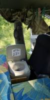 Portable toilet set up inside the GBB26 campervan next to the bed