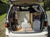 Tailgate open on the FQK81 campervan, showing the portable toilet, sink unit and fresh water container