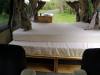 Inside the KZR927 campervan looking forward over the bed to the sink unit and the open side door