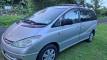Driver's side of the silver ERT416 Toyota Estima campervan parked on grass