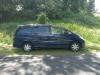 Side view of the dark blue Toyota Estima campervan FDK492 parked on a country road
