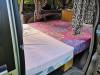 Side door open on the FPS382 campervan with the double bed made up across the van
