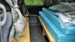 Inside the FJD528 campervan, bed on its plywood base with bedding, storage shelves underneath