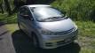 Front three-quarter view of the silver Toyota Estima campervan, registration FBE338, parked in dappled shade