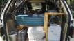 Tailgate open on the GQG541 campervan, showing the bed, kitchen unit, portable toilet and water container