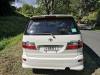 Back of the white Toyota Estima campervan with registration FQK81 and the green self-contained sticker