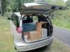 Tailgate open on the KHP570 campervan parked on a country road, kitchen unit and water container inside