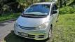 Front of the silver 2000 Toyota Estima campervan on a tree-lined country driveway
