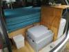 Portable toilet and chilly bin stowed under the sink unit in the JNQ545 campervan