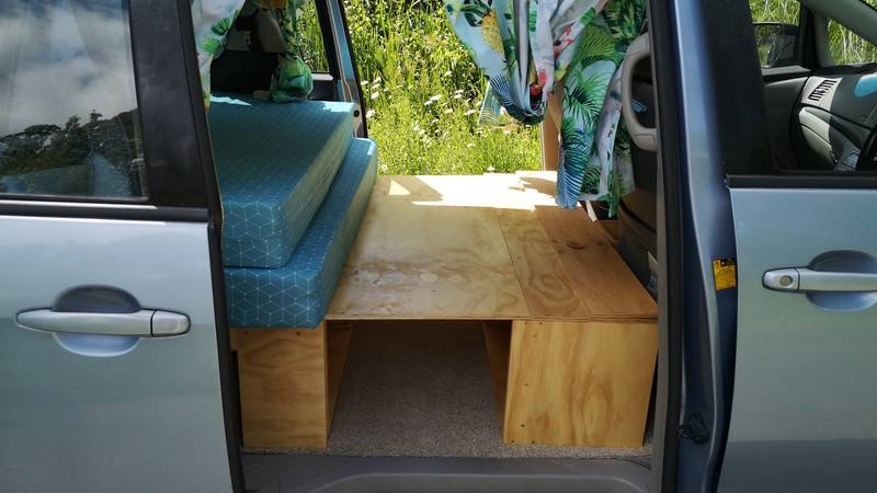 Side door open on the DJR846 campervan, bed cushion on its plywood base with the step box alongside