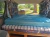 The FDK492 campervan's double bed made up, looking out through the open tailgate