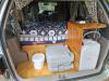 Tailgate open on the FPS382 campervan, showing the bed, sink unit, portable toilet and water container