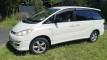 Side view of the white Toyota Estima campervan GQG541 parked on a grass verge