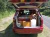 Tailgate open on the red JAK653 campervan, showing the bed, kitchen unit and fresh water container
