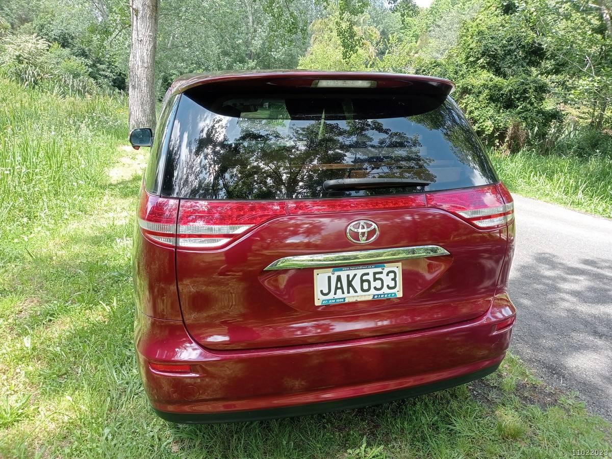 Back of the red Toyota Estima campervan with registration JAK653