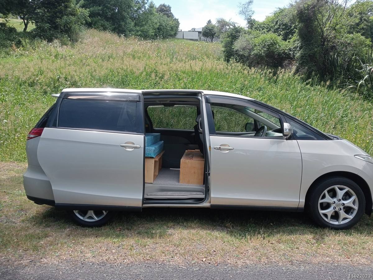 Side view of the gold Toyota Estima campervan KHP570 with the side door open
