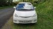 Front of the white Toyota Estima campervan with registration FAC789, parked on a country road verge