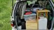 Tailgate open on the FJD528 campervan, packed with the kitchen unit, storage boxes and water container