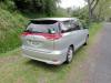 Rear three-quarter view of the silver 2006 Toyota Estima campervan JNQ545 on a country road