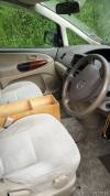 Driver's seat, steering wheel and wood-trim door of the JBB773 Toyota Estima campervan